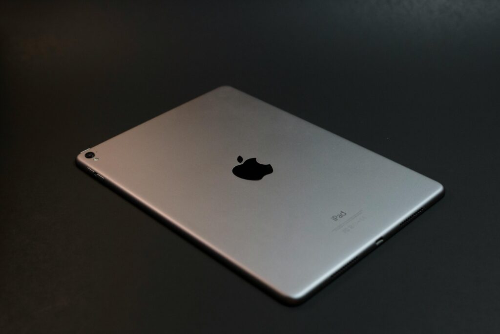 A modern silver tablet with a sleek design on a dark surface, showcasing advanced technology.