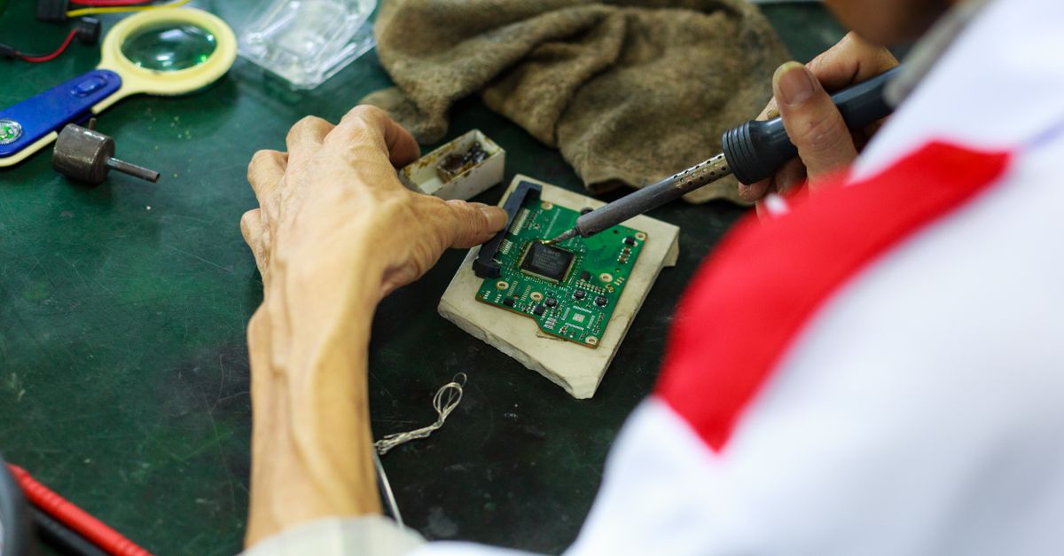 A skilled technician uses a soldering iron to repair and solder a circuit board.