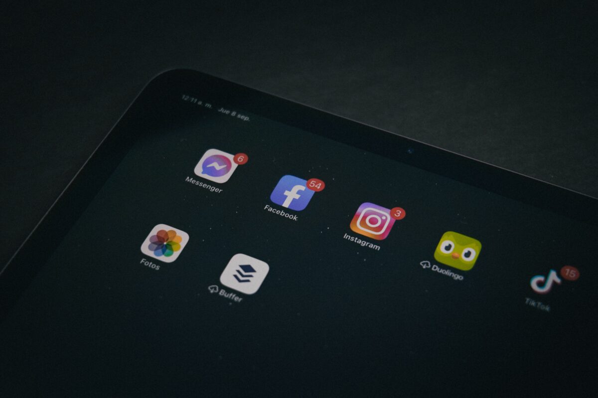 A tablet displaying popular apps like Facebook and Instagram in a dimly lit setting.