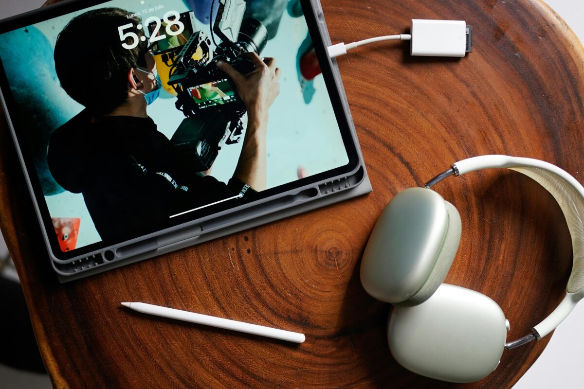 A modern setup featuring a tablet and headphones on a wooden table, showcasing creativity and technology.