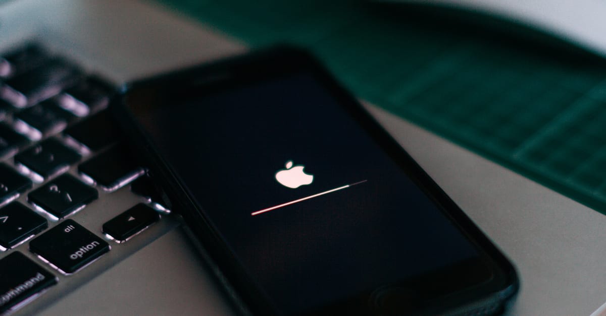 Close-up of a smartphone charging on a laptop. Ideal for tech themes.
