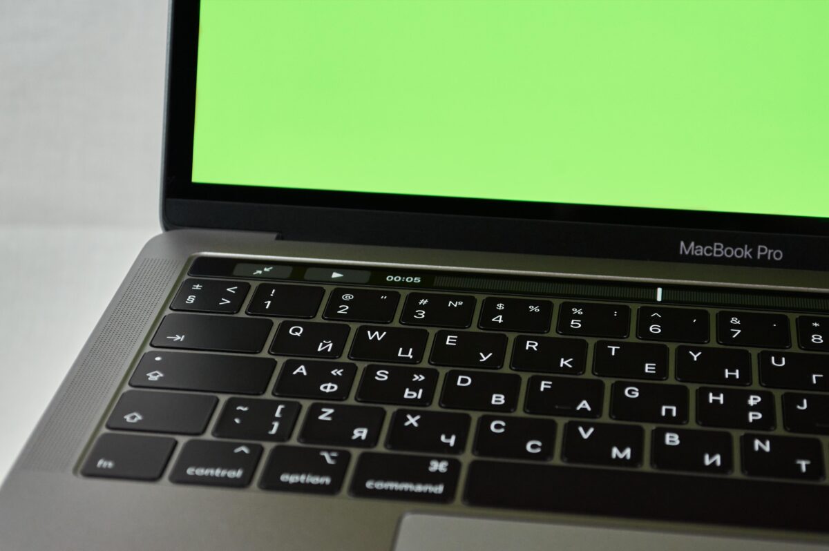 Russian keyboard MacBook Pro with a green screen. Modern electronic device.