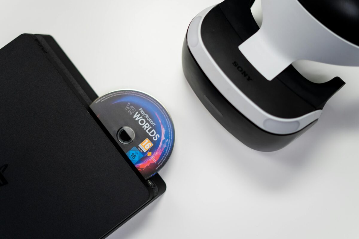 Overhead view of PlayStation console, VR headset, and game disc on a white background.