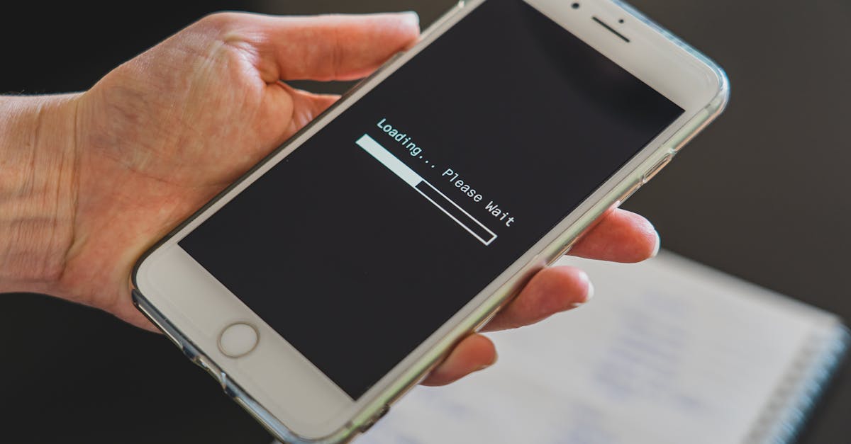 Close-up of a hand holding a smartphone with a loading screen displayed, showcasing technology usage.