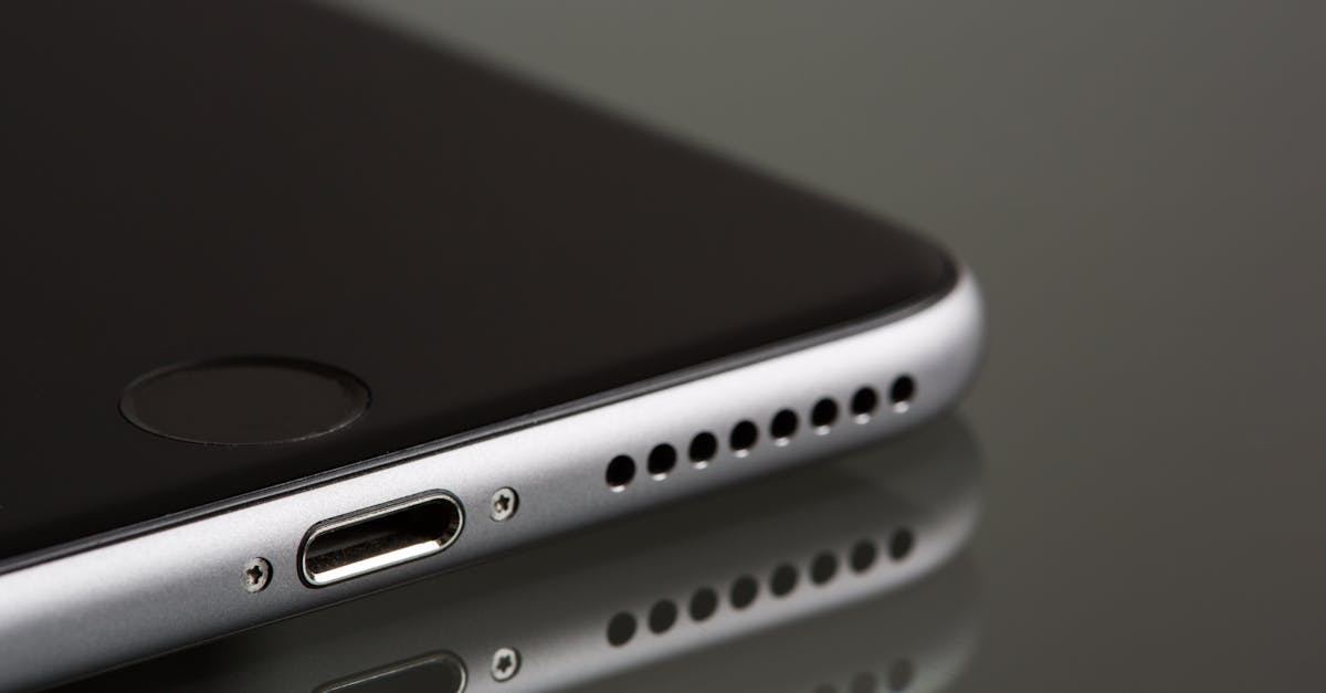 A sleek smartphone close-up highlighting its lightning connector and speaker, reflecting on a surface.