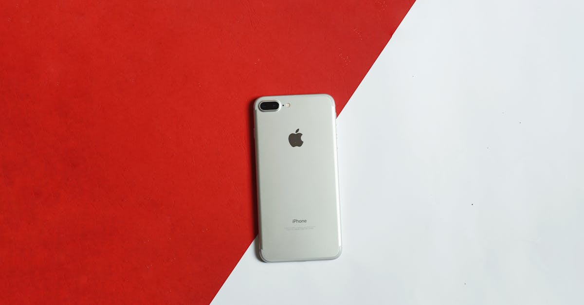 A silver smartphone placed on a contrasting red and white background captured from above.