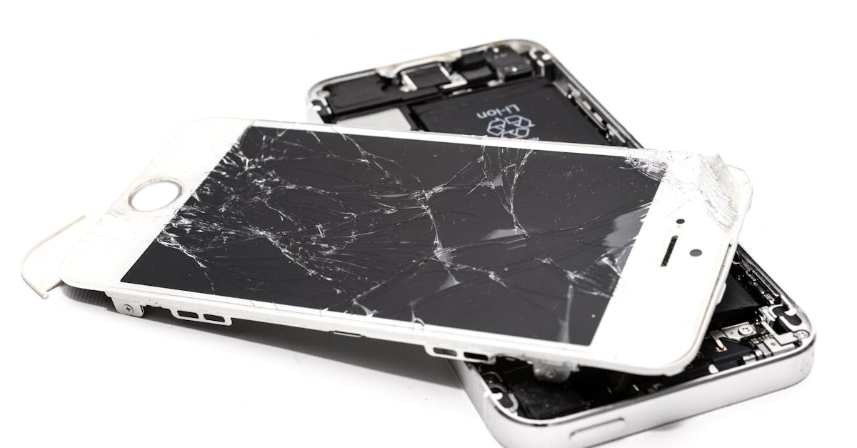 Close-up of a broken smartphone with a severely cracked screen.